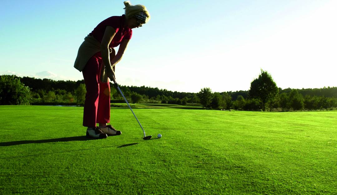 Eine Dame beim Golfen