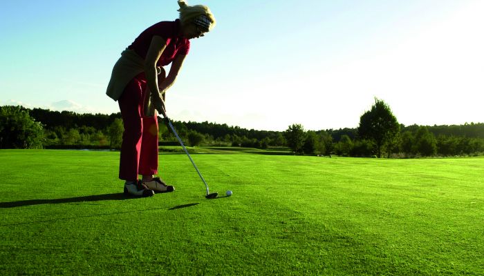 Eine Dame beim Golfen